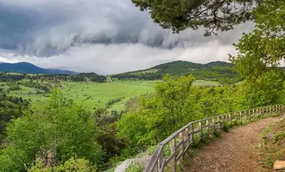 a fence on a hill with a view of a field at Barceló Apartment Velingrad in Velingrad