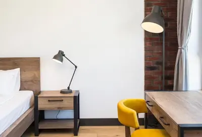 a bedroom with a bed and a desk with a lamp at Complex Gallery Vitosha **** in Sofia