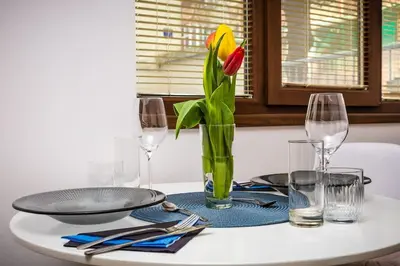 a table with a vase with a yellow flower in it at 'Little Little' House in the town CENTER & PARKING in Plovdiv