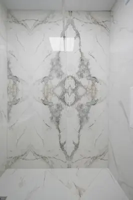 a bathroom with a white marble shower stall with a shower at Green Eyes Apartments in Sofia
