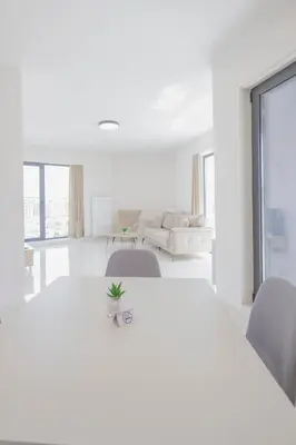 a white room with a white table and chairs at Green Eyes Apartments in Sofia