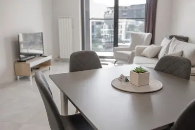 a living room with a table and chairs and a tv at Green Eyes Apartments in Sofia