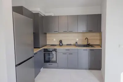 a kitchen with stainless steel appliances and gray cabinets at Green Eyes Apartments in Sofia