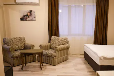 a hotel room with a bed and two chairs and a table at Hotel Leda in Sofia