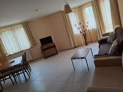 a living room with a couch and a table and a tv at Apartment 322, Villa Park in Borovets