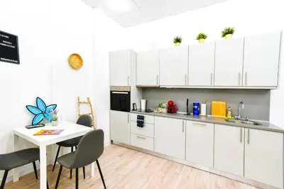 a kitchen with white cabinets and a table with chairs at Duplex Condo Prime Location 2BTH 2 Studios in Sofia