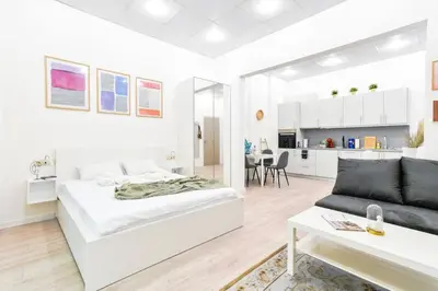 a white bedroom with a bed and a couch at Duplex Condo Prime Location 2BTH 2 Studios in Sofia