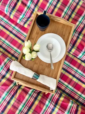 a plate and spoon on a tray on a bed at Flower house 7 in Sofia