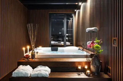 a bathroom with a tub with candles and towels at Abrazo Sofia Hotel by HMG in Sofia