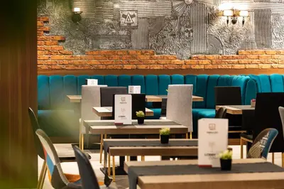 a restaurant with tables and chairs and a blue couch at Abrazo Sofia Hotel by HMG in Sofia