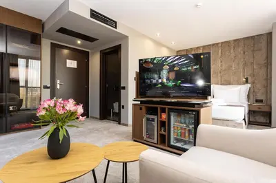 a living room with a tv and a couch and a table at Abrazo Sofia Hotel by HMG in Sofia