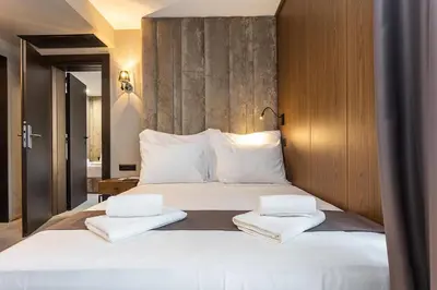 a bedroom with a large white bed with two towels at Abrazo Sofia Hotel by HMG in Sofia