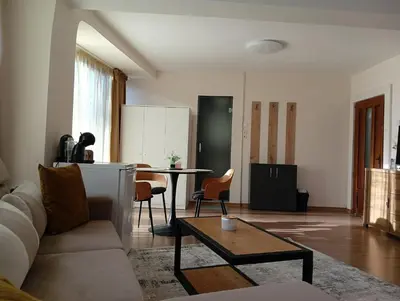 a living room with a couch and a table at Cozy studio with FRENCH WINDOWS in Plovdiv