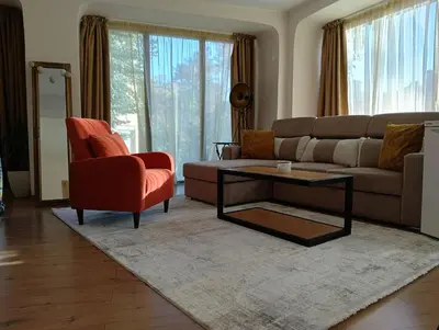 a living room with a couch and a chair at Cozy studio with FRENCH WINDOWS in Plovdiv