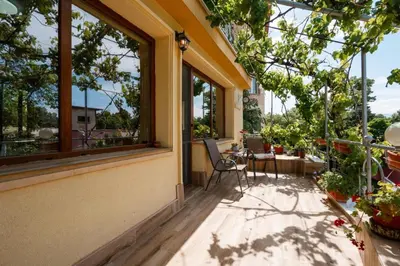 a balcony with a table and chairs and windows at Cozy Apartment Green Terrace in Plovdiv