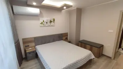 a bedroom with a bed with a white bedspread at Апартамент Relax in Smolyan
