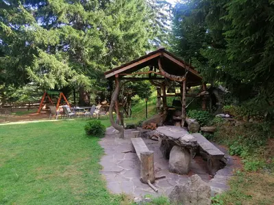 a wooden pavilion with a bench in a park at Студио 