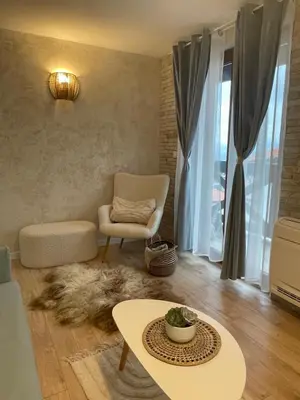 a living room with a chair and a table at Boutique apartment Bansko Bell Tower in Bansko