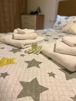 a bed with stars on it with towels on it at Апартамент Ламартин- в сърцето на Пловдив in Plovdiv