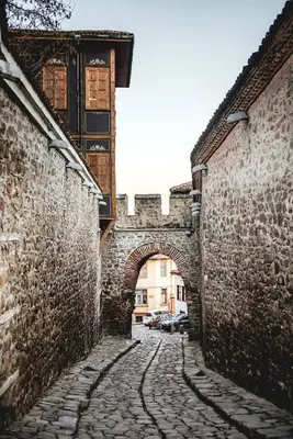 an alley with an archway between two stone buildings at Апартамент Ламартин- в сърцето на Пловдив in Plovdiv