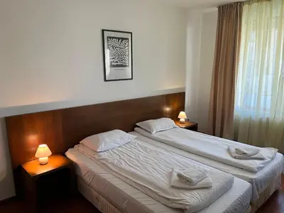 a hotel room with two beds and two lamps at Ski & Relax Apartments in Bellevue Residence in Bansko