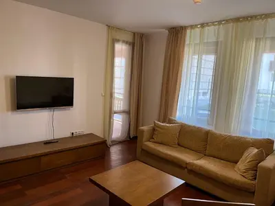 a living room with a couch and a flat screen tv at Ski & Relax Apartments in Bellevue Residence in Bansko