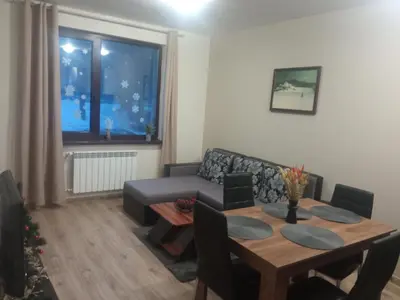 a living room with a table and a couch at Apartment E23 Borovets Gardens in Borovets