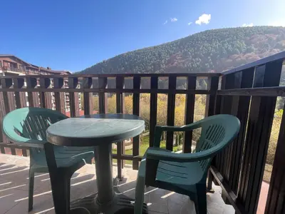 a table and chairs on a balcony with a view of a mountain at Мия 3 Спа хотел Свети Спас in Velingrad