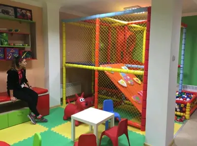 a child in a play room with a table and chairs at Apartment Sam in Grand Monastery in Pamporovo