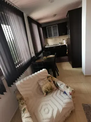 a living room with a couch and a kitchen at Apartment Sam in Grand Monastery in Pamporovo