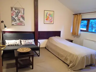 a bedroom with a bed and a table at Конна база и Къща за гости Дворене in Razlog