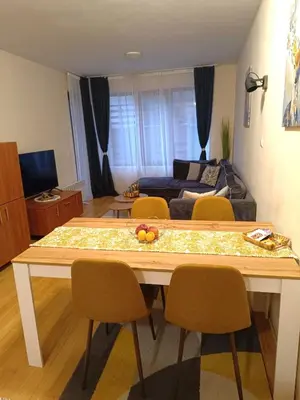 a living room with a table with chairs and a couch at Bansko Apartment Predela the One in Bansko