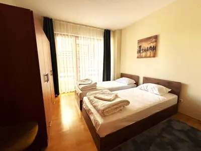 two beds in a room with a window at Bansko Apartment Predela the One in Bansko