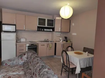 a kitchen with a couch and a table in a room at Слънчев апартамент с прекрасна гледка, паркинг. in Smolyan