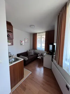 a living room with a couch and a kitchen at Jordan Apartment’s Bansko in Bansko