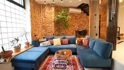 a living room with a blue couch and a brick wall at Modern and Spacious 3-Bedroom Entire House in Sofia