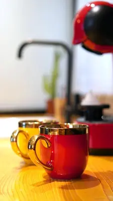 two red and gold coffee mugs sitting on a table at Modern and Spacious 3-Bedroom Entire House in Sofia