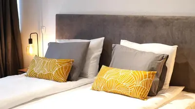 a bed with yellow and white pillows on it at Modern and Spacious 3-Bedroom Entire House in Sofia