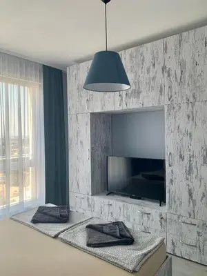 a living room with a large tv and a wall with aphalt at Blue loft & 2bedrooms & parking in Sofia