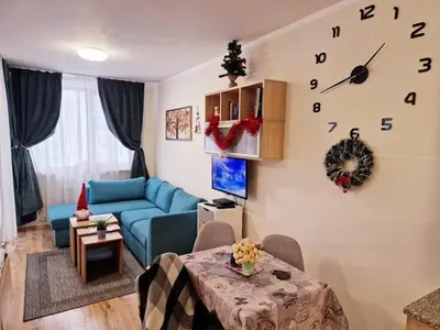 a living room with a blue couch and a clock on the wall at NEAT STUDIOS in 
