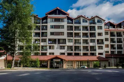 a large white apartment building with a red roof at NEAT STUDIOS in 