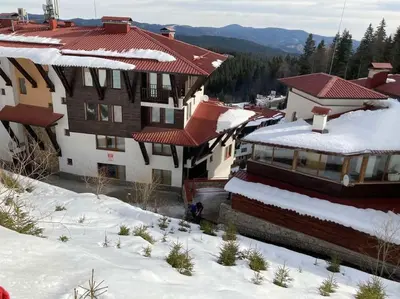 a group of buildings in the snow with snow covered roofs at Grand Monastery Apartment in Pamporovo