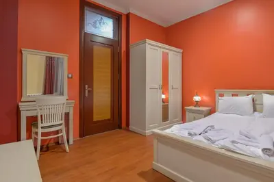 a bedroom with orange walls and a bed and a chair at Life in Colors - Elegant 2BD Premium Stay by Flat Mаnager in Sofia