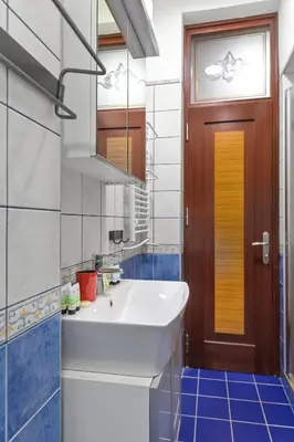 a bathroom with a white sink and a wooden door at Life in Colors - Elegant 2BD Premium Stay by Flat Mаnager in Sofia