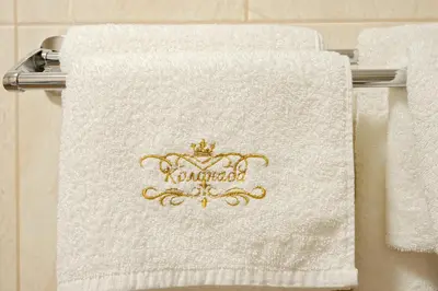 a white towel with a crown on top of it at Комплекс Колонада in Hisarya