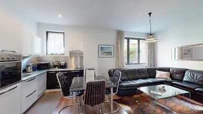 a living room with a black leather couch and a table at A Lovely 2BR Apartment in the heart of Sofia - NDK in Sofia
