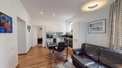 a living room with a leather couch and a table at A Lovely 2BR Apartment in the heart of Sofia - NDK in Sofia