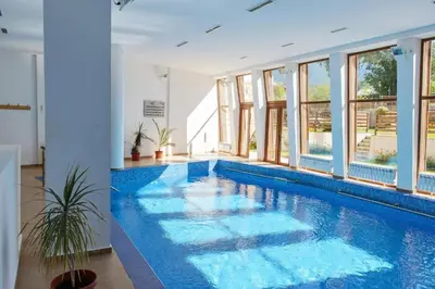 a large swimming pool with blue water in a house at Ski to door at Mountain View 1BR condo Bansko in Bansko