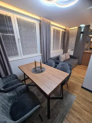 a living room with a table and a couch at Апартамент Мегилукс 2 in Blagoevgrad
