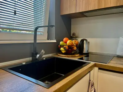 a kitchen with a sink and a bowl of fruit at Апартамент Мегилукс 2 in Blagoevgrad